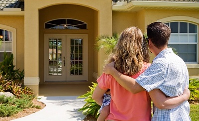 couple standing in front of their new home