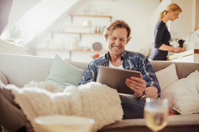 man sitting on sofa with tablet