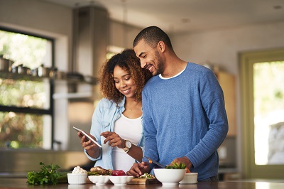 couple in kitchen looking at tablet