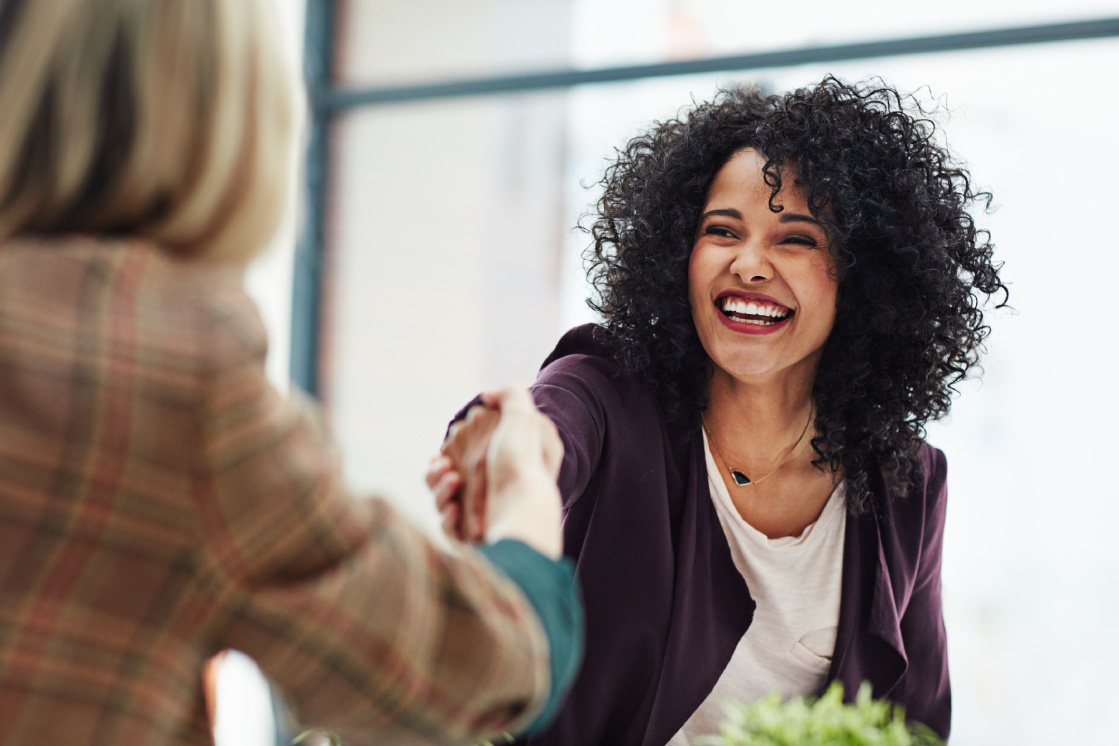 Women shaking hands at a credit union while becoming a member